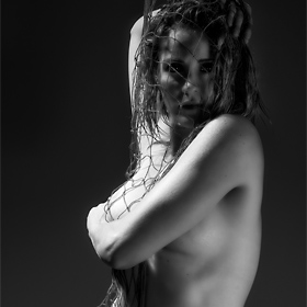 Fine art nude with fish net and 3-point studio lighting.