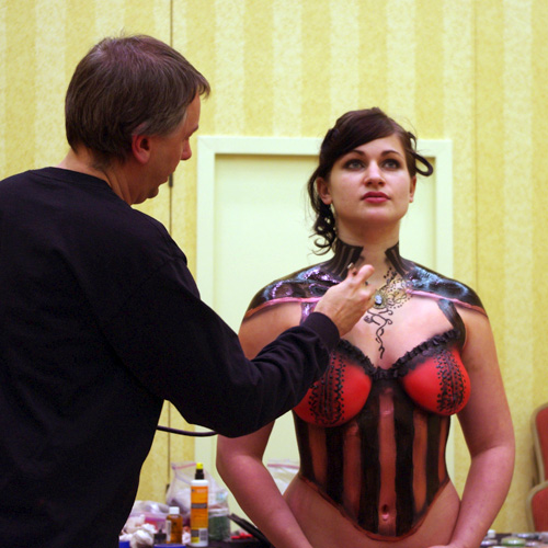 Applying liquid latex through a squeeze bottle on a live model