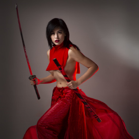 Red outfit is touched by a rim light of red while soft light illuminates her determined face.