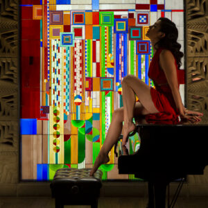 Girl in red dress at Arizona Biltmore piano at stained glass