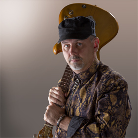 Rock Star Mark Greenawalt holding his Ibanez Electric Guitar like a baseball bat